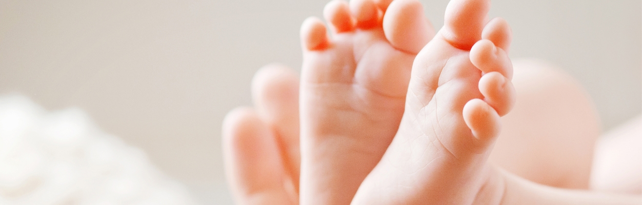 Adult cupping baby's feet